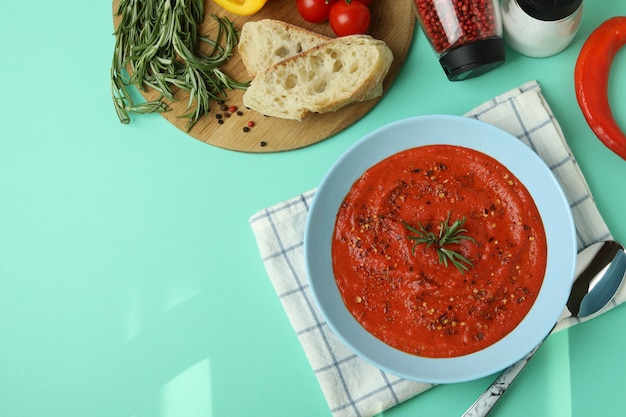 Concept of tasty eating with Gazpacho soup on mint background