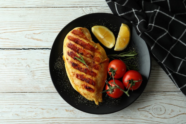 Concept of tasty eating with grilled chicken on white wooden table