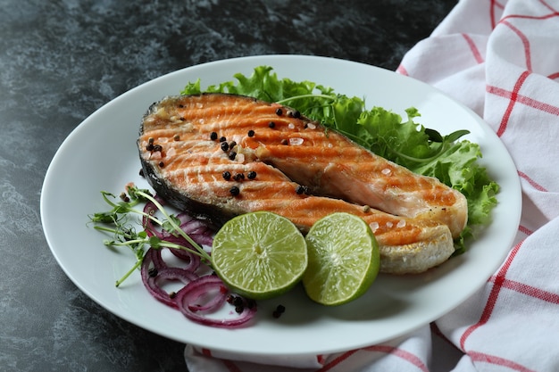 Концепция вкусной еды с жареным лососем на черном дымчатом фоне
