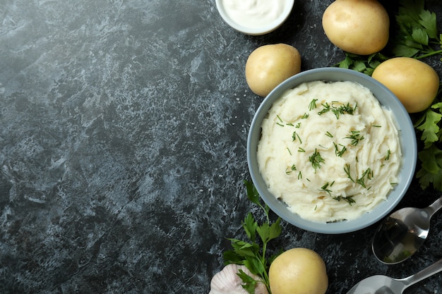 Concept of tasty eating with mashed potatoes on black smokey table