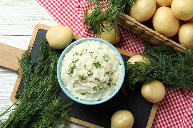 Concetto di mangiare gustoso con purè di patate su un tavolo di legno bianco