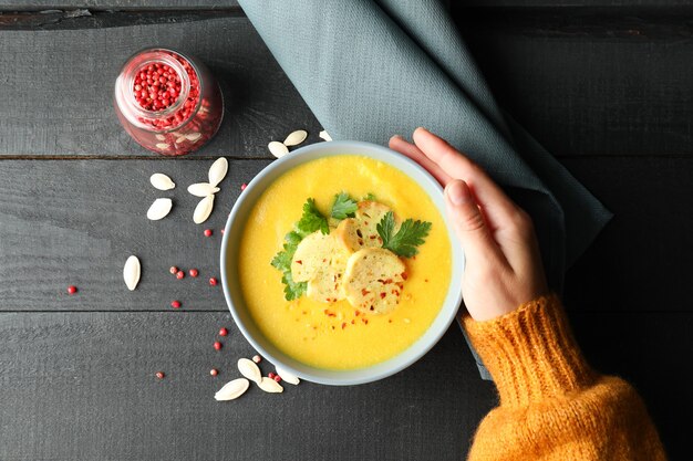 Concept of tasty eating with pumpkin soup on wooden table