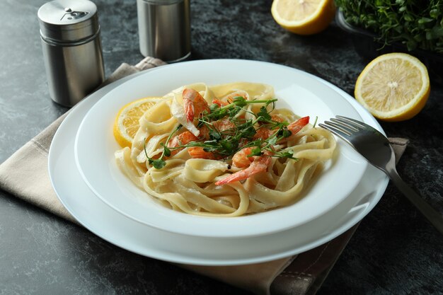 Concept of tasty eating with shrimp pasta on black smokey table