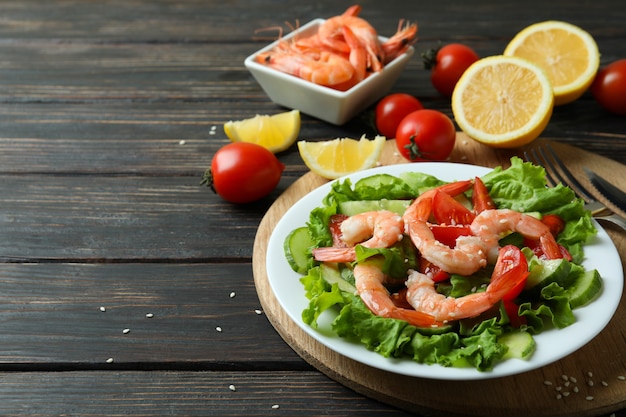 Photo concept of tasty eating with shrimp salad on wooden table