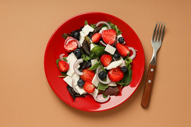 Concept of tasty food on brown background salad with strawberry