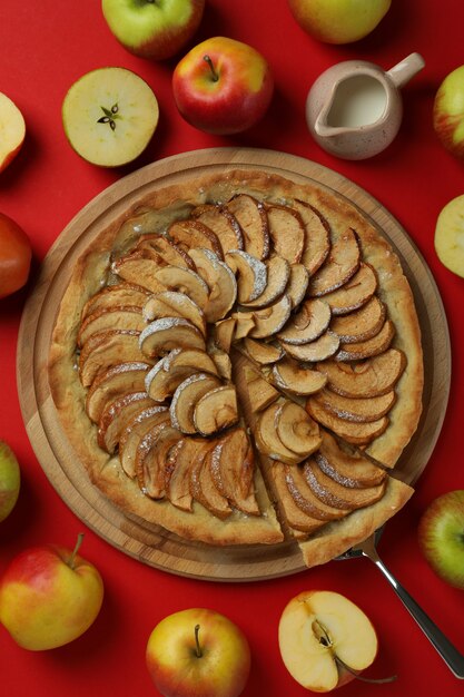 Concept of tasty food with apple pie on red background