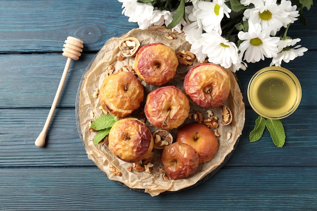 Concept of tasty food with baked apples on wooden table