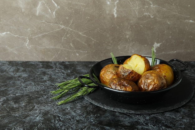 Concept of tasty food with baked potato on black smokey table.