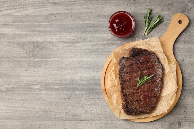 Concept of tasty food with beef steak on gray wooden background