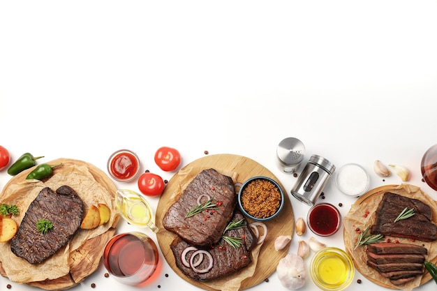 Concept of tasty food with beef steaks on white background