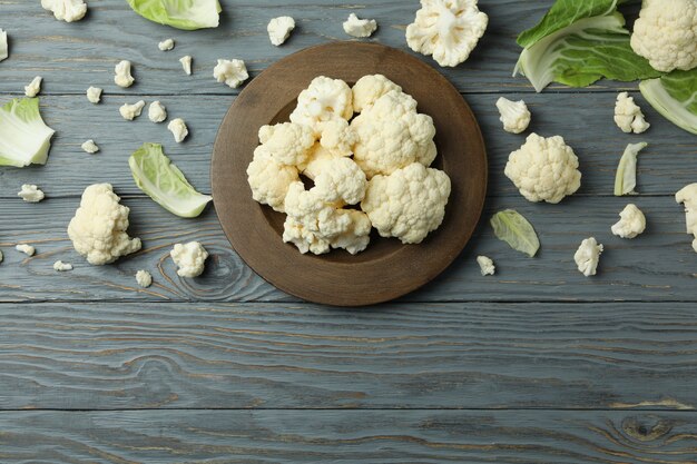 Photo concept of tasty food with cauliflower on wooden background