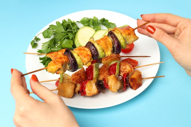 Concept of tasty food with chicken shashlik on blue background