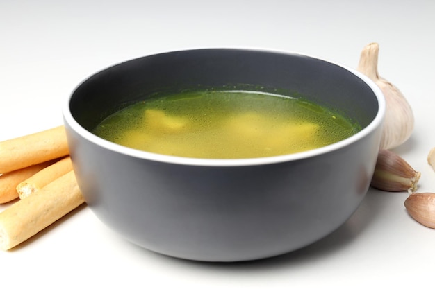 Concept of tasty food with chicken soup or broth on white background