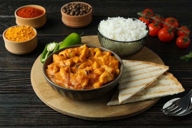 Concept of tasty food with chicken tikka on wooden background