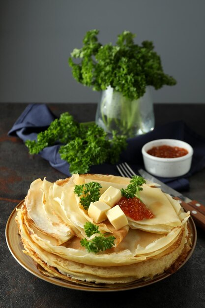 Concept of tasty food with crepes on dark textured table