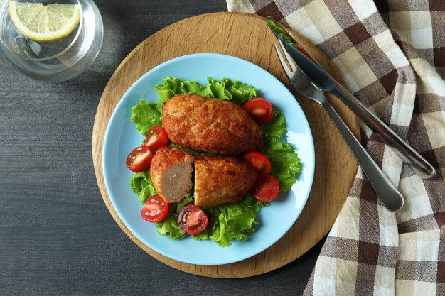 Concept of tasty food with cutlets on dark wooden table