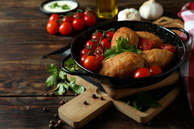 Concept of tasty food with cutlets on wooden table