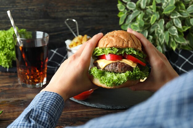 Concetto di cibo gustoso con delizioso hamburger