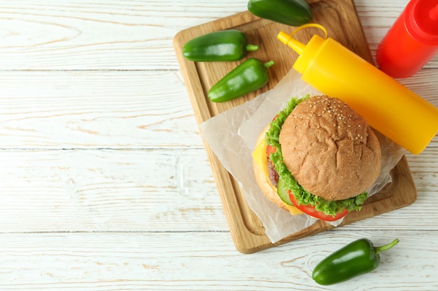 Concetto di cibo gustoso con delizioso hamburger