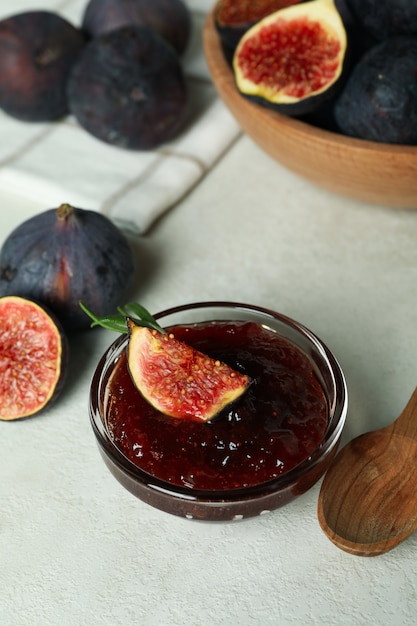 Photo concept of tasty food with fig jam on white textured background