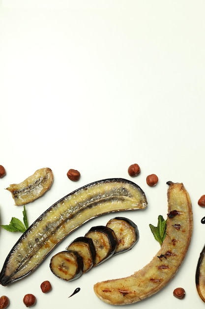 Concept of tasty food with grilled banana on white background