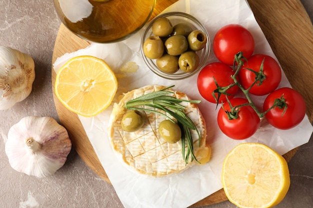 Concept of tasty food with grilled camembert on gray texture table.