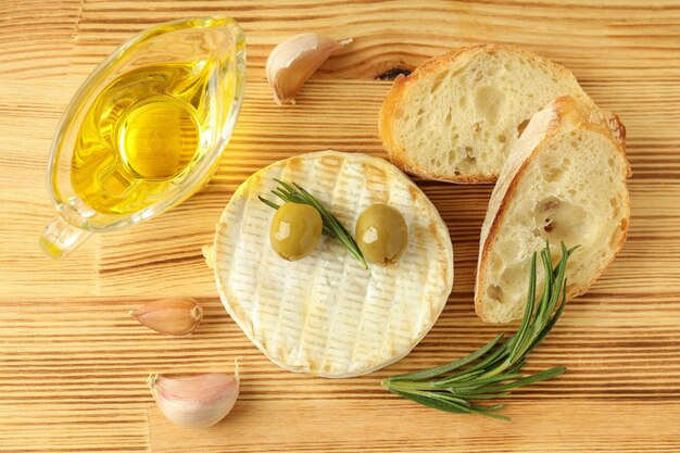 Concept of tasty food with grilled camembert on wooden background.