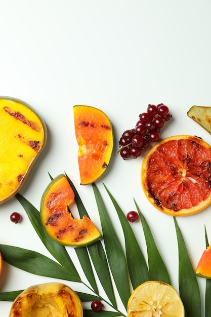 Concept of tasty food with grilled fruits on white background.