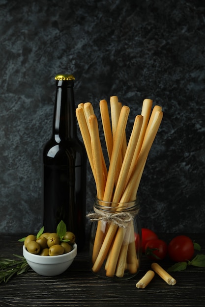 Concept of tasty food with grissini breadsticks on wooden table