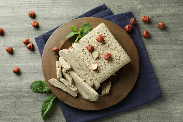 Concept of tasty food with halva on gray wooden background