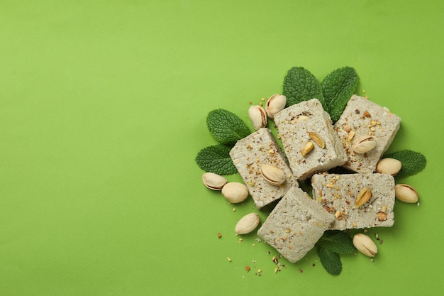 Concept of tasty food with halva on green background