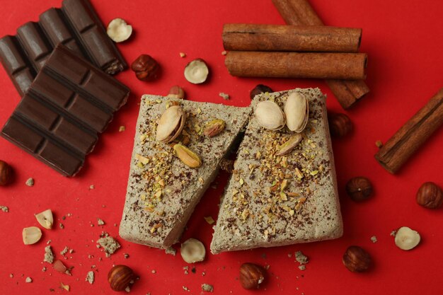 Concept of tasty food with halva on red background