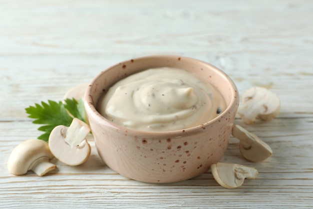 Photo concept of tasty food with mushroom sauce on white wooden background