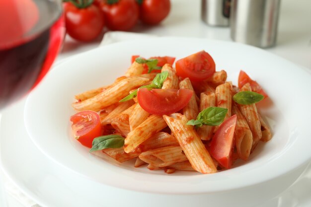 Concetto di cibo gustoso con pasta con salsa di pomodoro su bianco