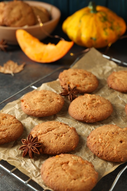 Concept of tasty food with pumpkin cookies on dark textured background.