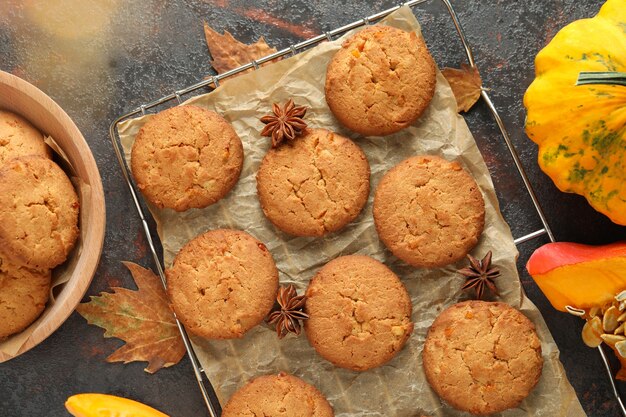 Concetto di cibo gustoso con biscotti di zucca su sfondo scuro con texture.