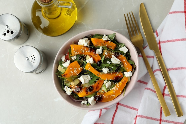 Concept of tasty food with pumpkin salad on light background