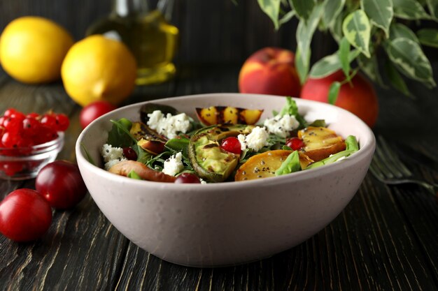 Concept of tasty food with salad with grilled peach on wooden table