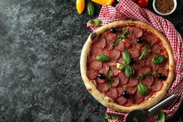 Concept of tasty food with Salami pizza on dark background