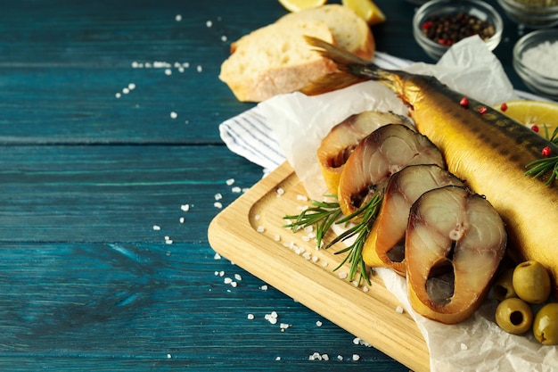 Concept of tasty food with smoked mackerel on wooden background