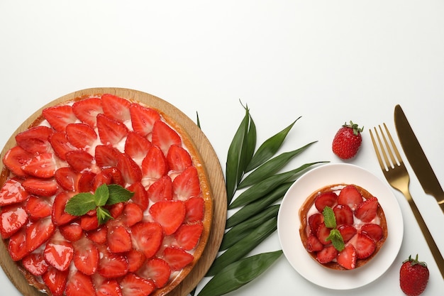 Concept of tasty food with strawberry tart on white background.