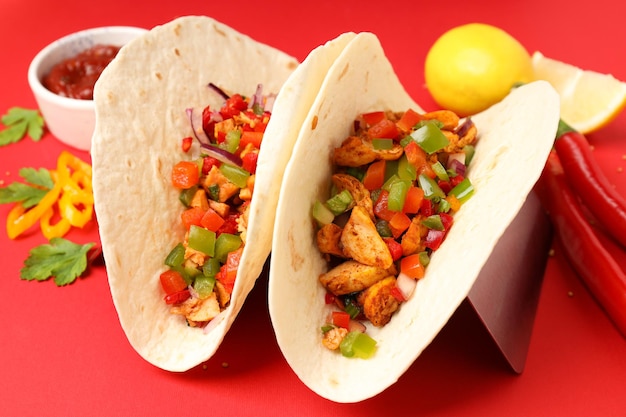 Concept of tasty food with taco on red background