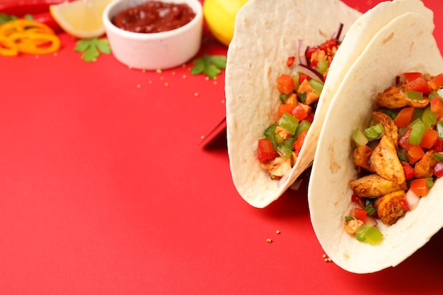 Concept of tasty food with taco on red background