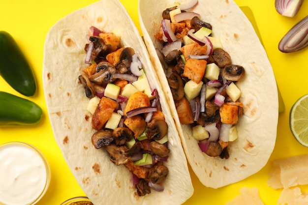 Concept of tasty food with taco on yellow background