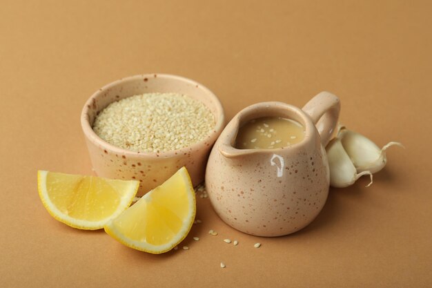 Concept of tasty food with tahini sauce on beige background