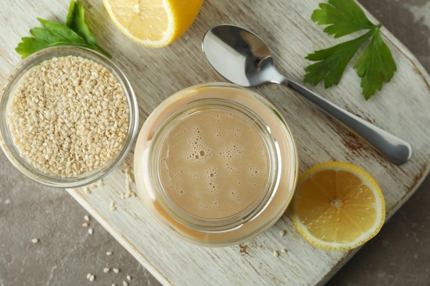 Concept of tasty food with tahini sauce on beige textured background