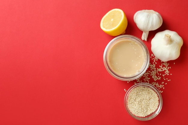 Concept of tasty food with tahini sauce on red background