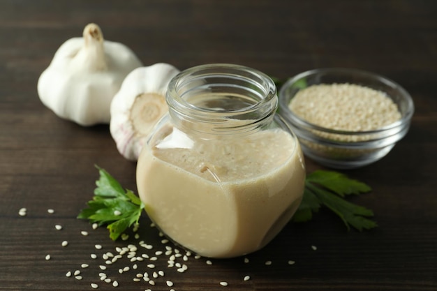 Concept of tasty food with tahini sauce on wooden background