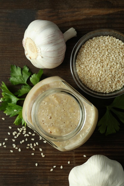 Concetto di cibo gustoso con salsa tahini su fondo in legno