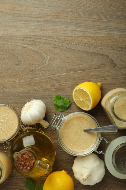 Concetto di cibo gustoso con salsa tahini su fondo in legno